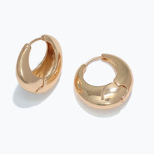 Close-up of 14K gold polished huggies earrings with secure hinge closure