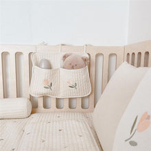 Bedside baby storage bag hanging on crib for holding diapers and bottles

