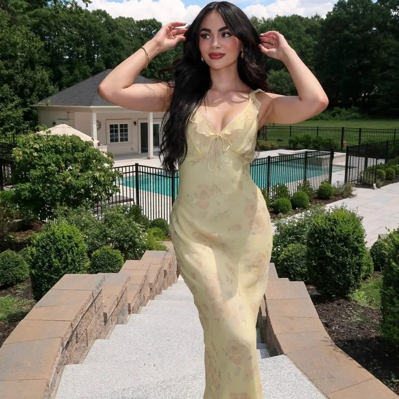 Woman wearing a vibrant summer floral maxi dress with a plunging neckline and backless design, perfect for beach vacations.