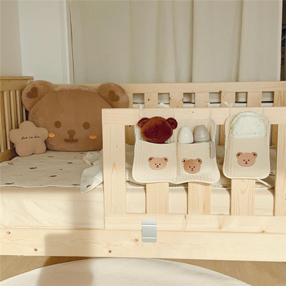 Bedside baby storage bag hanging on crib for holding diapers and bottles

