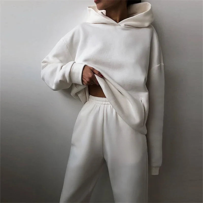 Woman wearing warm oversized hoodie tracksuit set in autumn

