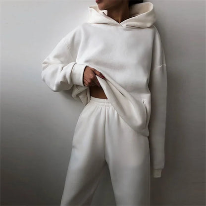 Woman wearing warm oversized hoodie tracksuit set in autumn

