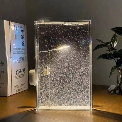 Warm LED snowfall night lamp glowing in a cozy winter bedroom

