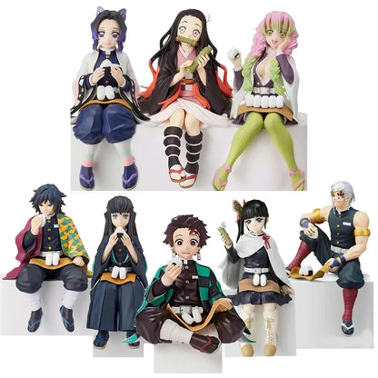 A collection of anime action figures from the series Demon Slayer, featuring characters in sitting postures. The figures vary in color and detail, representing different characters from the show.