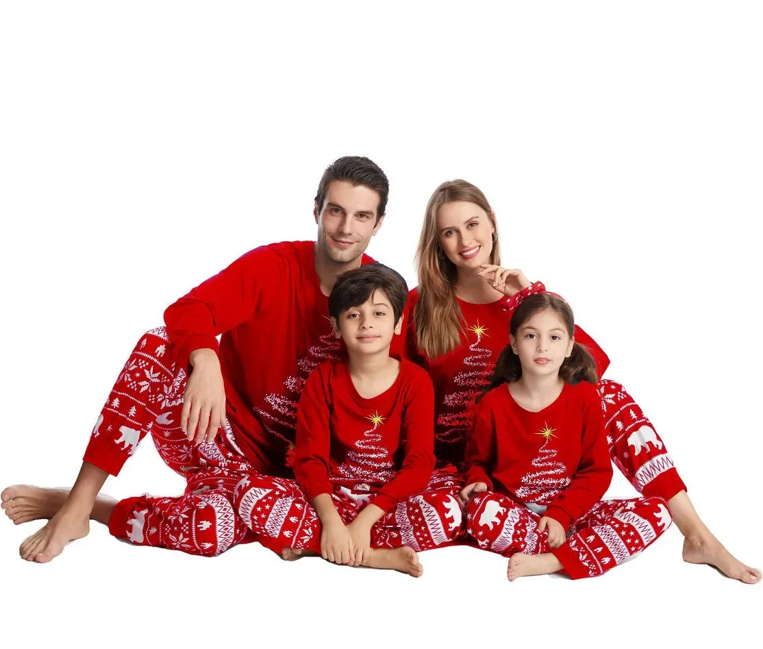 Family wearing matching polar bear and tinsel tree Christmas pajamas

