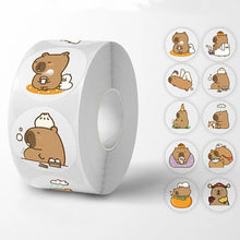 A roll of stickers featuring cute capybara illustrations in various playful poses, with a selection of the sticker designs displayed next to it.