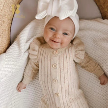 Woman wearing a stylish ruffle sleeve knitted jumpsuit in a cozy setting

