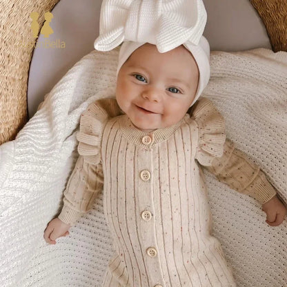 Woman wearing a stylish ruffle sleeve knitted jumpsuit in a cozy setting

