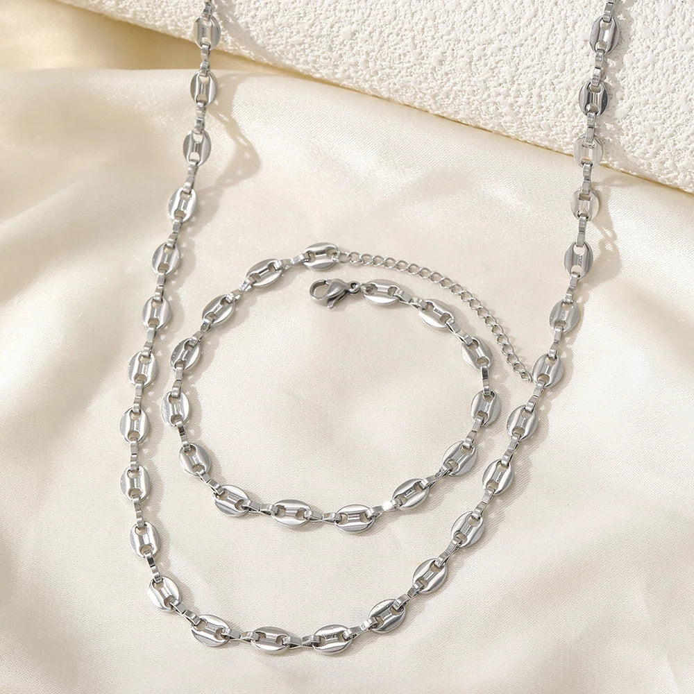 Stainless steel necklace and bracelet jewelry set on white background