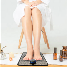 Person using portable EMS foot massager pad at home

