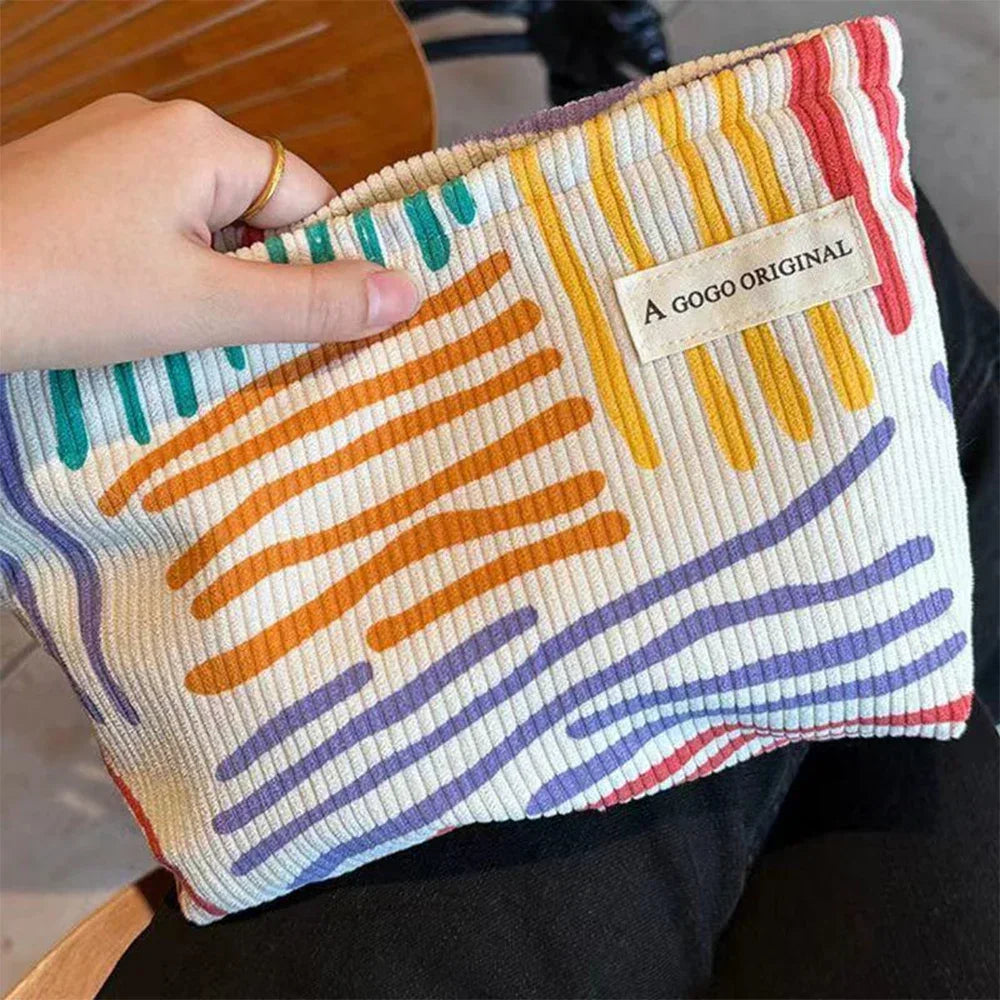 Corduroy cosmetic bag with colorful stripes for travel, skincare, and makeup storage


