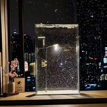 Warm LED snowfall night lamp glowing in a cozy winter bedroom

