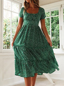 Woman in a vintage print maxi dress with puff sleeves and square collar, perfect for summer beach and casual outings.
