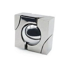 A metallic 3D puzzle toy with a spherical component centered within a geometric frame, likely made of steel or a similar metal.