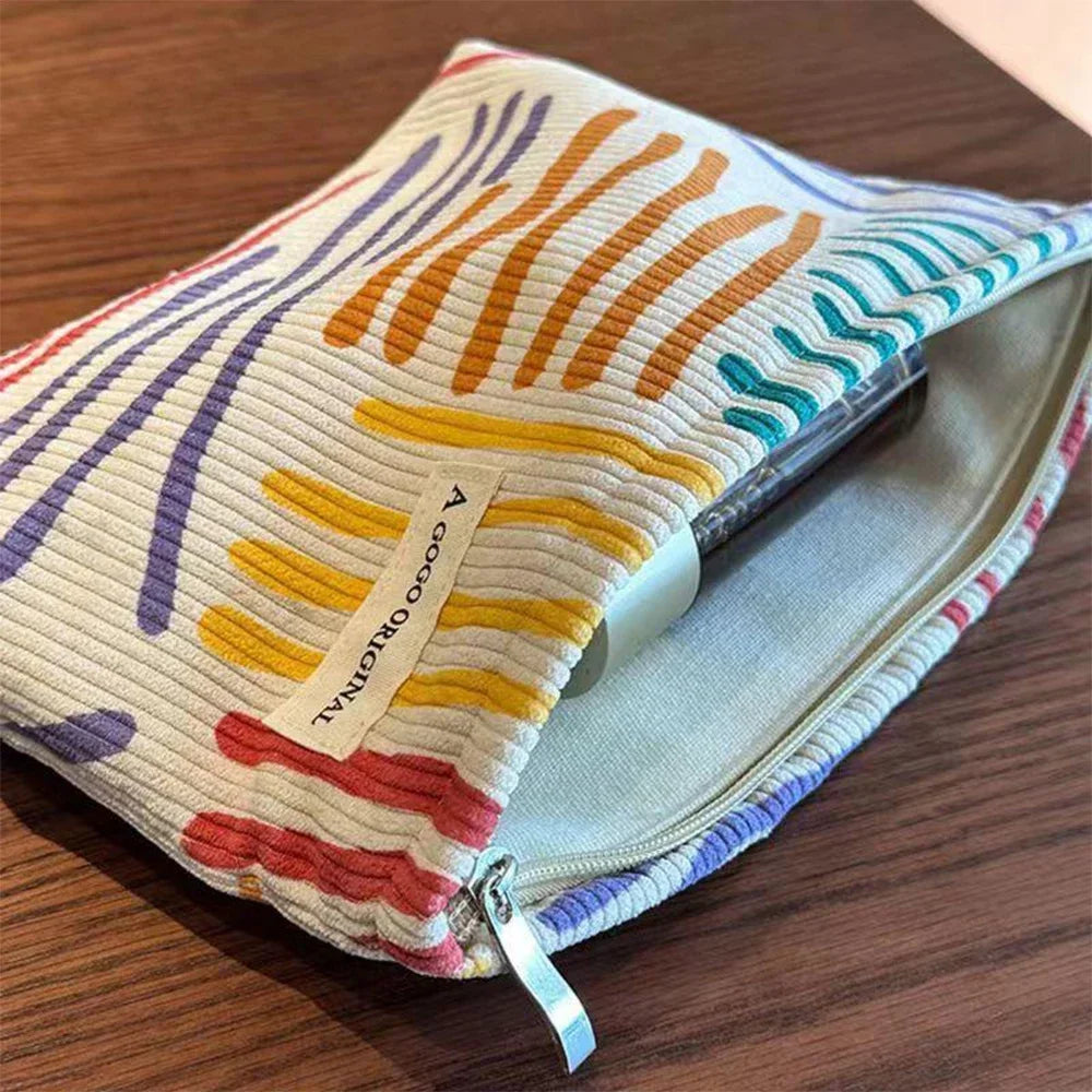 Corduroy cosmetic bag with colorful stripes for travel, skincare, and makeup storage

