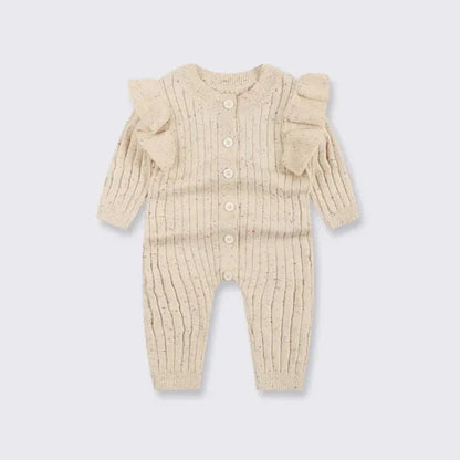 Woman wearing a stylish ruffle sleeve knitted jumpsuit in a cozy setting

