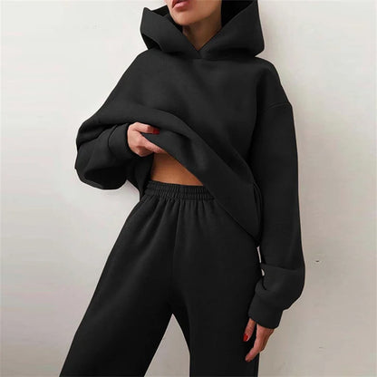 Woman wearing warm oversized hoodie tracksuit set in autumn

