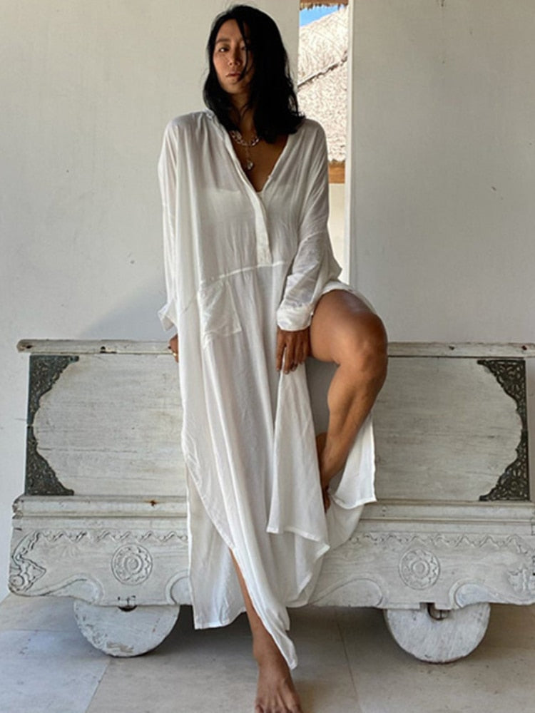 Woman wearing a white maxi beach dress kaftan as a swimsuit cover-up, perfect for summer beach and pool outings.