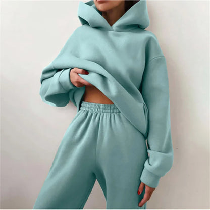 Woman wearing warm oversized hoodie tracksuit set in autumn

